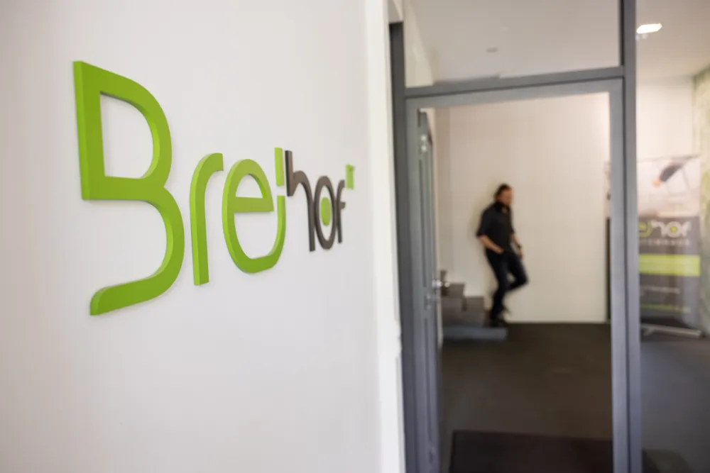 Grünes BREiHOF-Logo an der Wand im Eingangsbereich